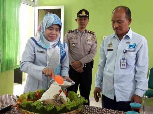 Kepala Dinas P3AP2KB melakukan pemotongan tumpeng dalam acara peletakan batu pertama pembangunan Balai Penyuluhan KB Kec. Mlati